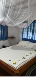 a bed with flowers on it in a bedroom at Mangrove Beach Bungalows in Utende