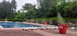 basen z białymi krzesłami i ludzie pływający w nim w obiekcie Bungalow de 2 chambres avec piscine partagee et terrasse amenagee a Saint Cheron w mieście Saint-Chéron