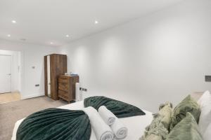 a living room with a bed with towels on it at Spacious Luxury Apartment King Bed - Central Location in London