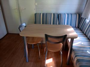 ein Tisch und zwei Stühle neben einer Couch in der Unterkunft Bungalow charmant avec piscine partagée à Saint-Chéron in Saint-Chéron + 10 Fotos