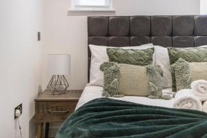 a bedroom with a bed with green sheets and pillows at Spacious Luxury Apartment King Bed - Central Location in London