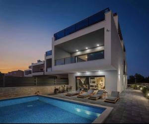 a large house with a swimming pool in front of it at BeOneLux in Srima