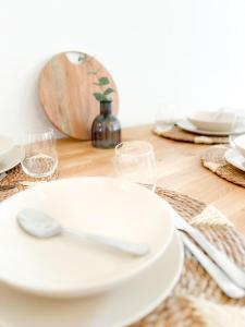 a table with a white plate and glasses on it at City Comfort Essen - Wohndomizil mit Balkon, Büro und Netflix in Essen