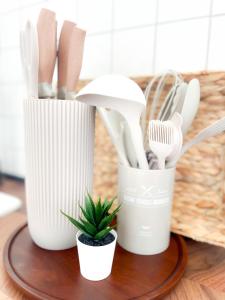 un groupe d'ustensiles et une usine sur une table dans l'établissement City Comfort Essen - Wohndomizil mit Balkon, Büro und Netflix, à Essen