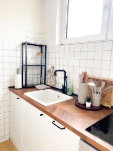 a kitchen counter with a white sink and a window at City Comfort Essen - Wohndomizil mit Balkon, Büro und Netflix in Essen