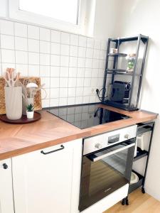 a kitchen with a counter top with a stove top oven at City Comfort Essen - Wohndomizil mit Balkon, Büro und Netflix in Essen