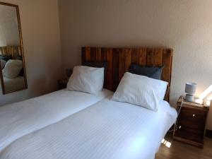 a bedroom with two beds with white sheets and a mirror at Maison de campagne en Limousin in Dury
