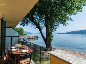 a table on a balcony with a view of the water at Residence Villa Greta in Meina