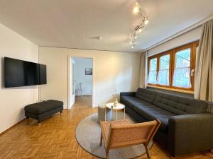 a living room with a couch and a tv at Bauernchalet Alois in Dornbirn
