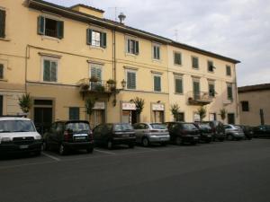 una fila di auto parcheggiate di fronte a un edificio di AL COLLEGIO, Centro Storico a Prato