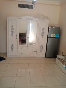 a kitchen with a white cabinet and a refrigerator at ORIENT TOWER STUDIO in Ajman 