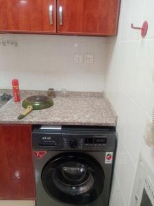 a kitchen with a washing machine on a counter at ORIENT TOWER STUDIO in Ajman 