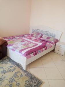 a bedroom with a bed with a quilt and a rug at ORIENT TOWER STUDIO in Ajman 