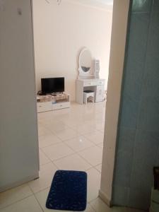 a bathroom with a tv and a mirror in a room at ORIENT TOWER STUDIO in Ajman 