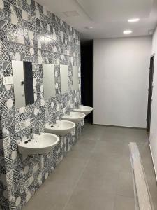 Baño con una fila de lavabos en una habitación en CafDorm, en Maribor