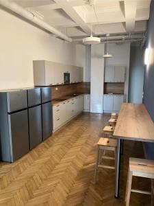 a large kitchen with wooden floors and white cabinets at CafDorm in Maribor