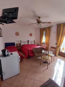 Schlafzimmer mit einem roten Bett, einem Tisch und Stühlen in der Unterkunft Al Calar Della Sera in Sommariva del Bosco