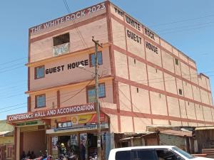 un edificio en la esquina de una calle con coches en The white rock 2023 en Eldoret