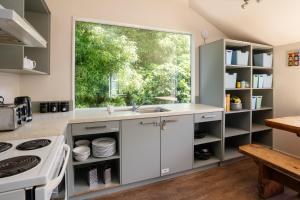 a kitchen with white cabinets and a large window at Haka Lodge Queenstown in Queenstown