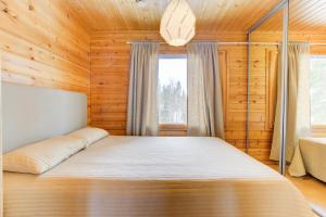 ピュハトゥントゥリにあるPyhäkoti Holiday Homeの木製の部屋にベッド1台が備わるベッドルーム1室があります。
