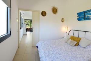 ein weißes Schlafzimmer mit einem Bett und einem Flur in der Unterkunft One bedroom appartement with terrace and wifi at Cadaques in Cadaqués