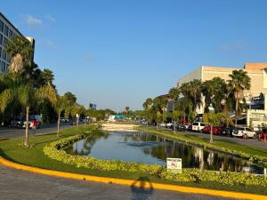 a street with a canal in a city with palm trees at Suites Athos4 in Cancún