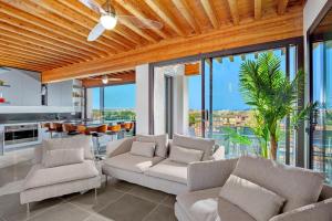 a living room with white furniture and glass windows at Villa Mirtillo Golfo Aranci in Golfo Aranci