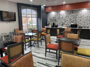 un restaurant avec des chaises, des tables et un comptoir dans l'établissement La Quinta by Wyndham OKC North - Quail Springs, à Oklahoma City