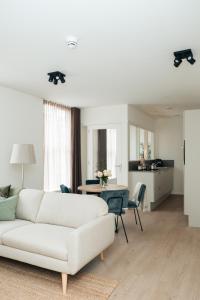 Urban Suites في أيندهوفن: غرفة معيشة مع أريكة بيضاء وطاولة