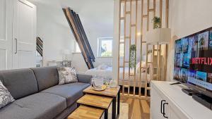 a living room with a couch and a tv at L'Eiffel entre centre-ville et parc Moulins Expo, avec services premium by PRIMO C0NCIERGERIE in Moulins