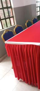 a red table in a room with chairs at The white rock 2023 in Eldoret