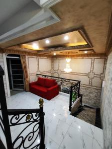 a red couch sitting on a balcony in a room at Rumah liburan 2 bedroom, 1 sofabed, 1 kitchen in Jakarta