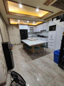 a large kitchen with a large table and stools at Rumah liburan 2 bedroom, 1 sofabed, 1 kitchen in Jakarta