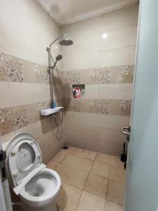 a bathroom with a toilet and a shower at Rumah liburan 2 bedroom, 1 sofabed, 1 kitchen in Jakarta