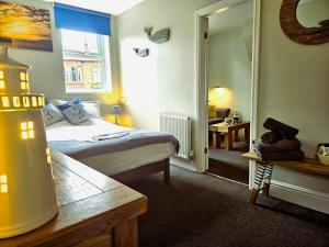 een slaapkamer met een bed en een kamer met een spiegel bij Ashburton House - B&B in Scarborough