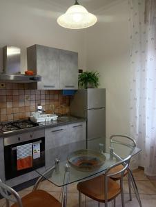 a kitchen with a glass table with chairs and a stove at Home Sweet Home in Bologna