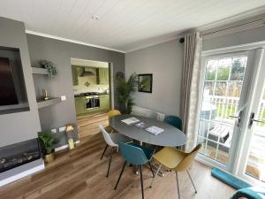 a living room with a dining room table and chairs at Windrush Turret Lodge in South Cerney