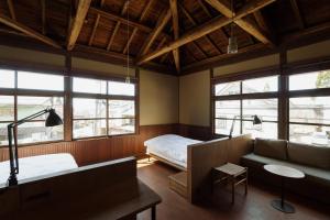 a bedroom with a couch and a bed and windows at awai 戸隠 in Nagano