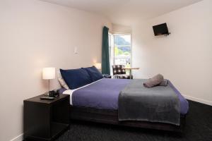 a hotel room with a bed and a window at Haka Lodge Queenstown in Queenstown