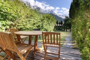 un tavolo e sedie in legno su una terrazza di legno di House Berenice - Chamonix les Praz a Chamonix-Mont-Blanc