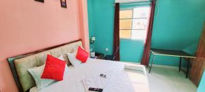 a bedroom with a white bed with red pillows at Hotel Ananya Inn in Varanasi