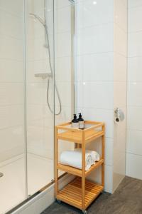 a bathroom with a shower and a shelf with a towel at Urban Suites in Eindhoven