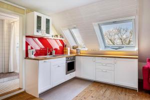 a kitchen with white cabinets and a window at Voßberg Fewo 2 in Grömitz