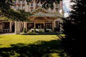 un grand bâtiment avec une pelouse devant lui dans l'établissement Gstaad Palace, à Gstaad