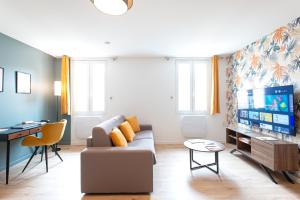 ein Wohnzimmer mit einem Sofa und einem Flachbild-TV in der Unterkunft L'Escale Ocre - 150m Restaurant 3 étoiles in Vonnas