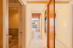 a hallway leading to a bathroom with a tub at MAREA ApartHotel in Vilanova i la Geltrú