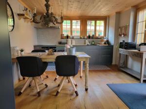 cocina con mesa de madera y 2 sillas en Mountain Lodge *Nature *Queen Beds *Free parking en Oberwil