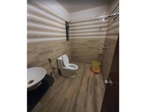 a bathroom with a toilet and a sink at Hotel Kamesh Hut, Varanasi in Varanasi