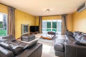 a living room with leather couches and a tv at Pinta Golf 275 in Carvoeiro