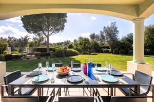 a table on a patio with a view of a yard at Pinta Golf 275 in Carvoeiro